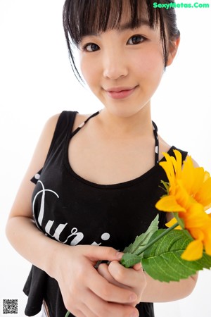 A woman in a black top and striped shorts posing for a picture.