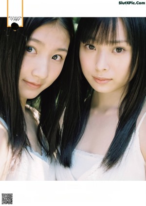 Two young women laying on top of a bed.