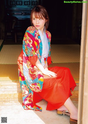 A woman in a red kimono is posing for the camera.