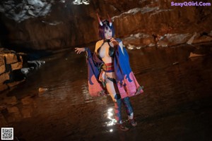 A woman dressed as a demon holding a blue lantern.