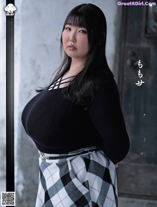 A woman in a black top and plaid skirt posing for a magazine.