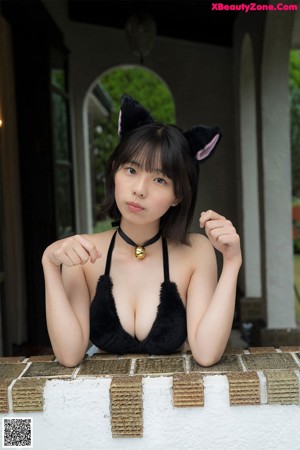 A woman in a black bikini with a cat ears on her head.