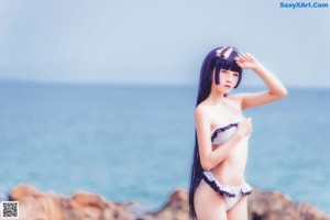 A woman in a bikini standing on a beach.