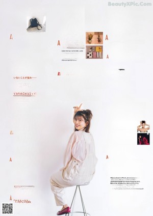 A woman in a brown sweater is posing for a magazine.