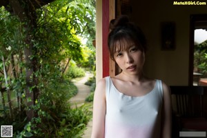 A woman standing in front of a red door.