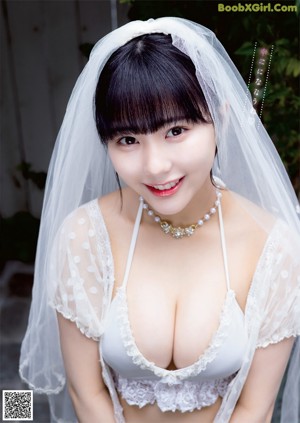 A woman in a wedding dress holding a bouquet of flowers.