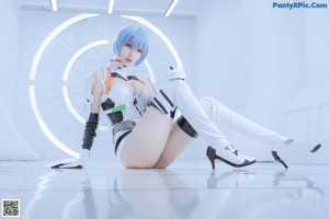 A woman laying on the floor in a white room.