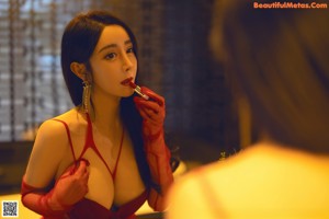 A woman in a red lingerie sitting on a counter.