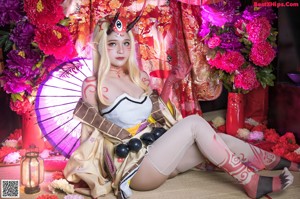 A woman in a kimono sitting on the floor holding an umbrella.