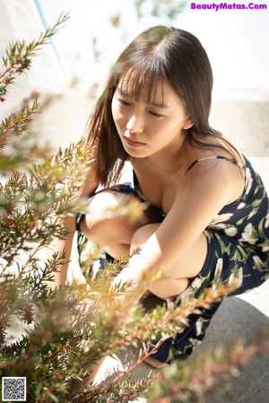 A woman laying on top of a bed next to a window.