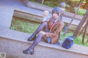 A woman in a school uniform sitting on a bench.