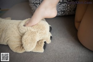 A woman sitting on a couch holding a teddy bear.