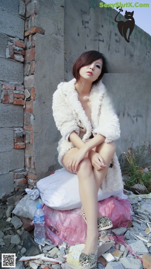 A woman in a white coat is posing for a picture.