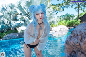 A woman with blue hair wearing a white shirt and black bikini.