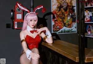 A woman in a bunny costume sitting on a stool.