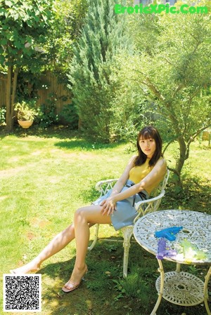 A woman in a yellow top is smiling at the camera.