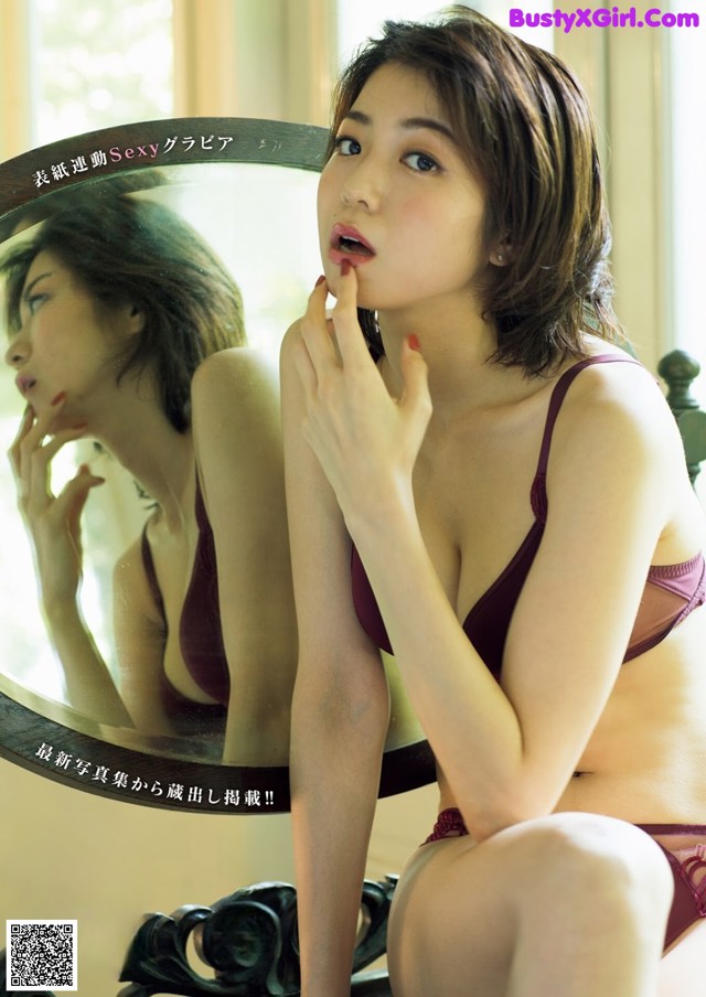 A woman in a red lingerie sitting in front of a mirror.