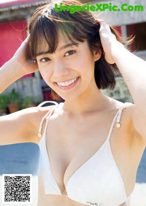 A woman in a white bikini posing for a magazine.