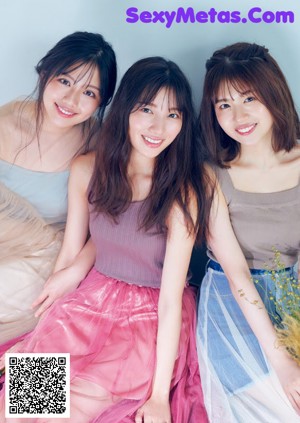 A group of young women sitting on top of a bed.