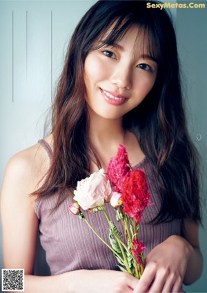 A woman laying on the ground surrounded by flowers.