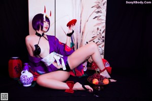A woman in a purple and black outfit posing for a picture.