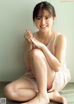 A woman in a pink dress smiling at the camera.