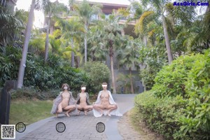 A group of naked women walking down a path in a park.