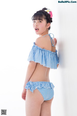 A woman in a blue and white gingham bikini posing for a picture.