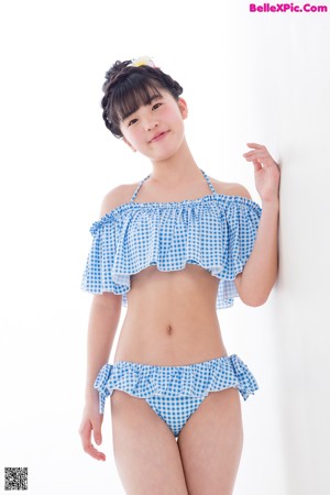 A woman in a blue and white gingham bikini posing for a picture.