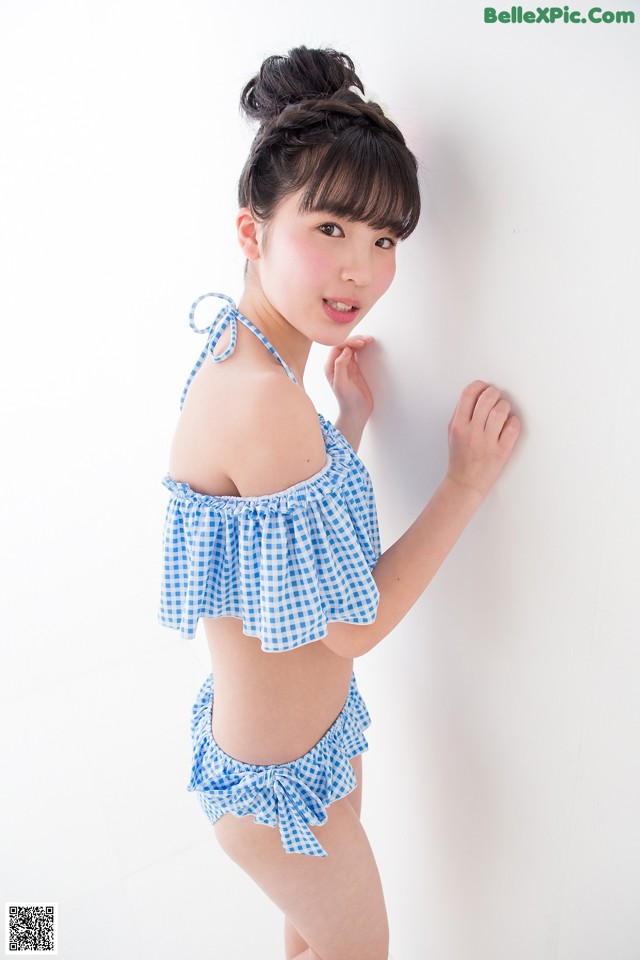 A woman in a blue and white gingham bikini posing for a picture.