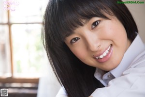 A young woman sitting on top of a wooden table.