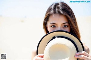 A woman wearing a straw hat is posing for a picture.