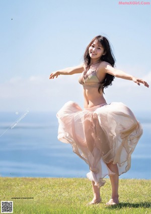A woman in a purple bikini standing on a beach.