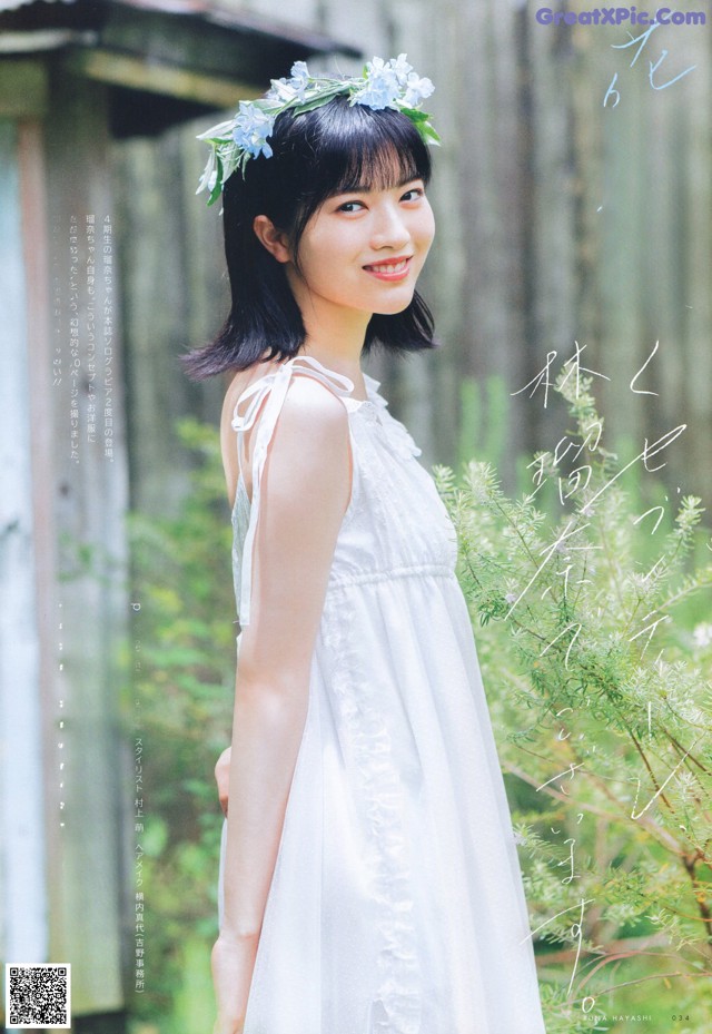 A woman in a white dress with a flower crown on her head.