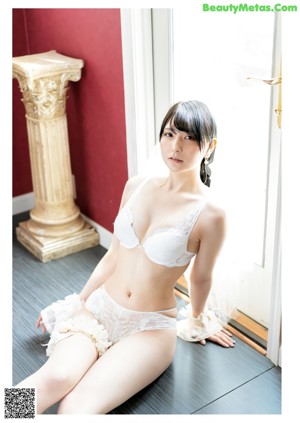 A woman in a white dress laying on a couch.