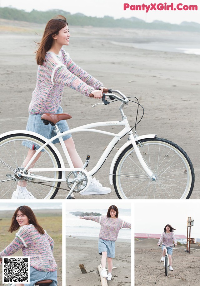 A woman riding a bike on a beach next to the ocean.