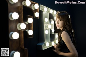 A woman in a blue dress posing in front of a mirror.