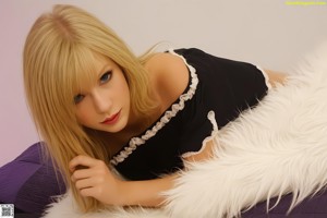 A woman in a blue shirt and white panties posing on a bed.