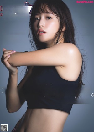 A woman in a black top and red skirt posing for a picture.