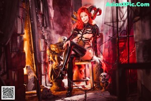 A woman dressed as a demon with horns and a mask.