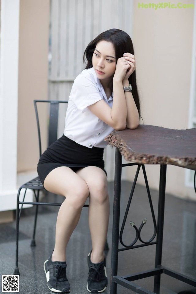 A woman sitting at a table with her legs crossed.