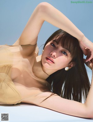 A woman in a black dress posing for a magazine.